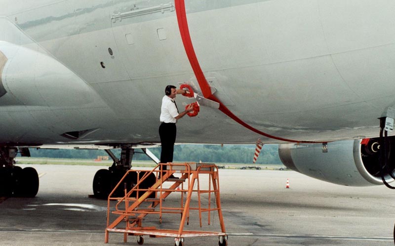 Crew cutting the ribbon around a plane in the 2002 opening celebration of Milan freighter service